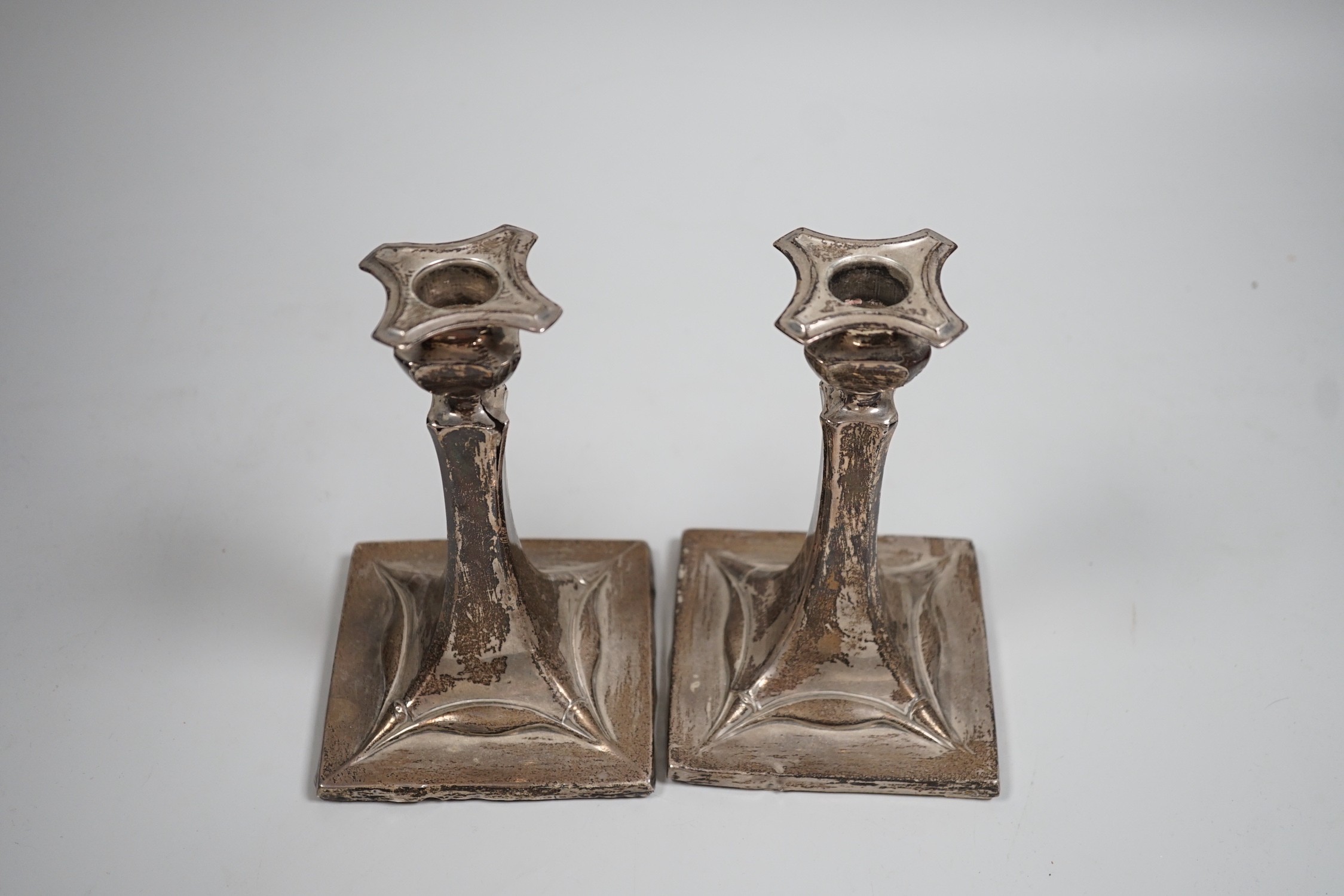 A pair of early 20th century Art Nouveau silver mounted candlesticks, marks rubbed (a.f.), height 15.2cm.